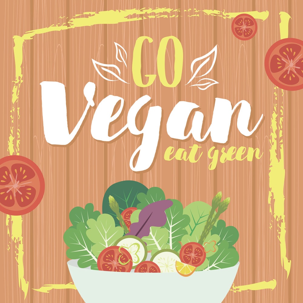 Illustration with "Go Vegan Eat Green" text above a bowl of assorted vegetables on a wooden background with tomato slices and yellow border accents.