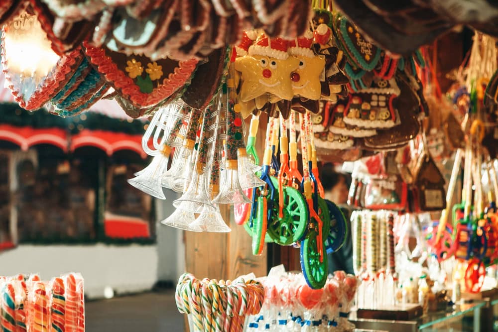 Assorted colorful sweets, candy canes, and decorated cookies displayed at a festive market stall.