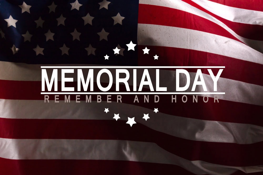 An American flag with the text "Memorial Day: Remember and Honor" centered over the flag, decorated with stars.