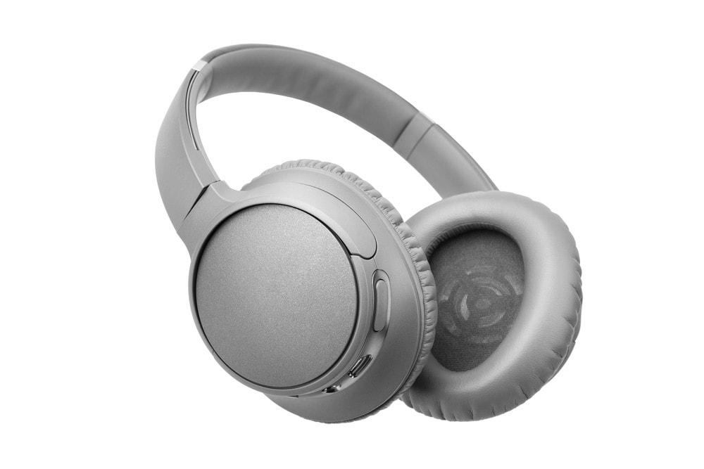 A pair of gray over-ear wireless headphones with cushioned ear pads and a padded headband, shown against a white background.