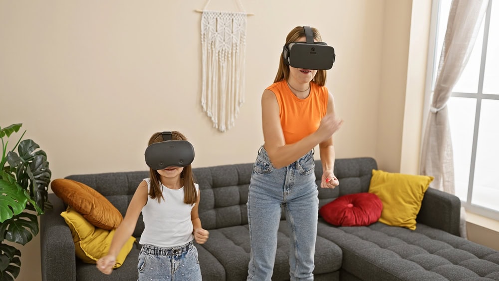 An adult and a child wearing VR headsets stand in a living room, appearing to interact with virtual reality content.