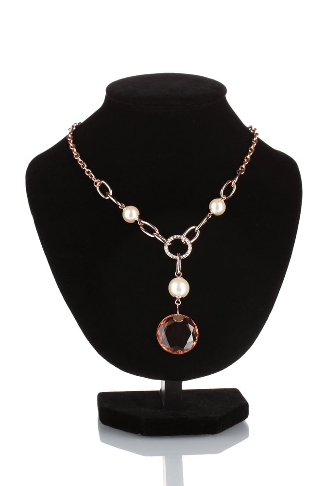 Gold chain necklace with large round brown gemstone pendant and pearl accents displayed on a black velvet bust stand.
