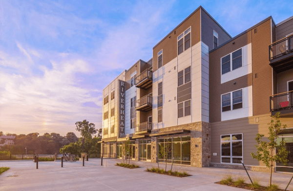 Modern multi-story apartment building with balconies, large windows, and 
